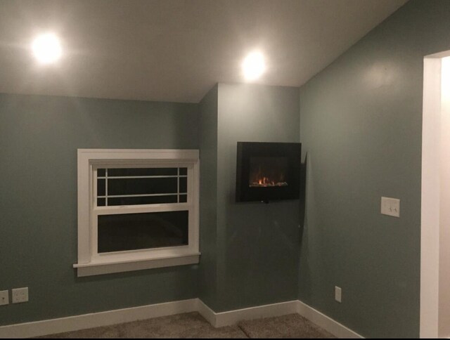 1116 Covell Ave NW, Grand Rapids, MI 49504 - detailed view of baseboards, carpet, and a lit fireplace