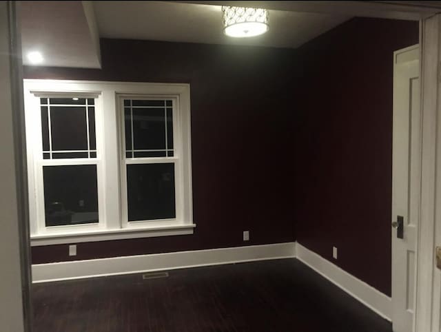 1116 Covell Ave NW, Grand Rapids, MI 49504 - spare room with baseboards and dark wood-style flooring