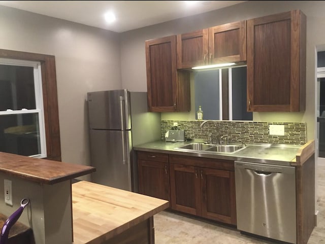 1116 Covell Ave NW, Grand Rapids, MI 49504 - kitchen featuring stainless steel appliances, a sink, tasteful backsplash, and stainless steel counters