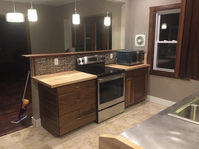 1116 Covell Ave NW, Grand Rapids, MI 49504 - kitchen featuring stainless steel appliances, butcher block counters, decorative backsplash, and decorative light fixtures