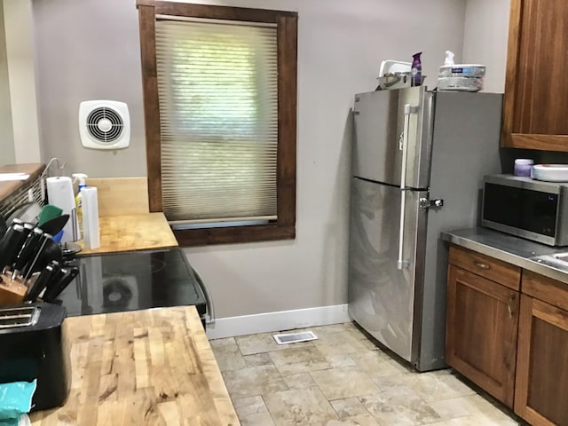 1116 Covell Ave NW, Grand Rapids, MI 49504 - kitchen featuring appliances with stainless steel finishes, wood counters, and brown cabinets