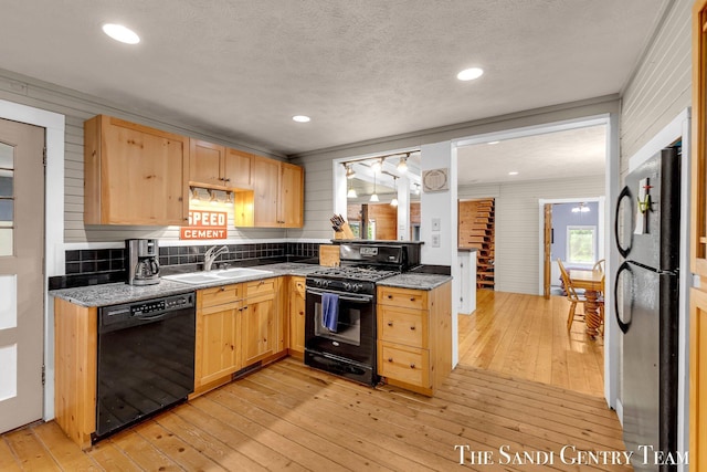 7120 Quarterline Rd, Spring Lake, MI 49456 - kitchen with black appliances, light brown cabinets, a sink, light wood-style floors, and a textured ceiling