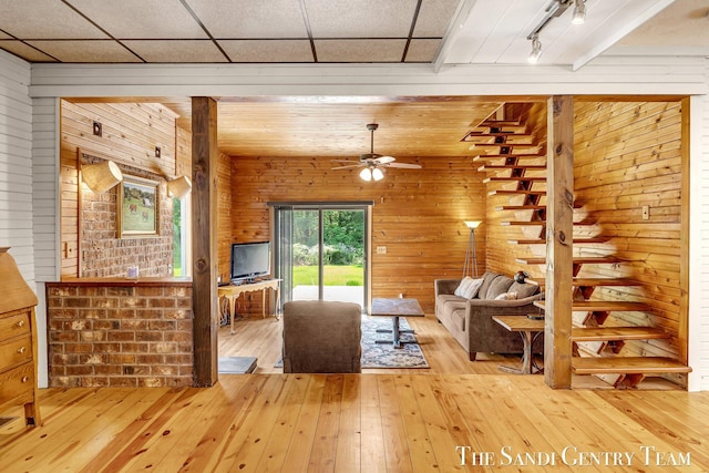 7120 Quarterline Rd, Spring Lake, MI 49456 - living room with light wood finished floors, wood walls, and a ceiling fan