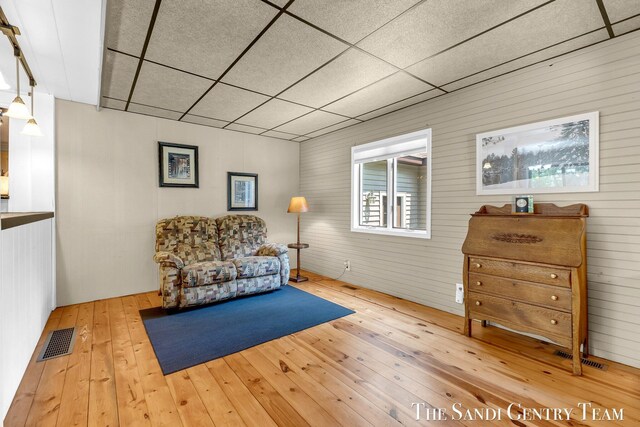 7120 Quarterline Rd, Spring Lake, MI 49456 - living area with wood-type flooring, a drop ceiling, and wood walls