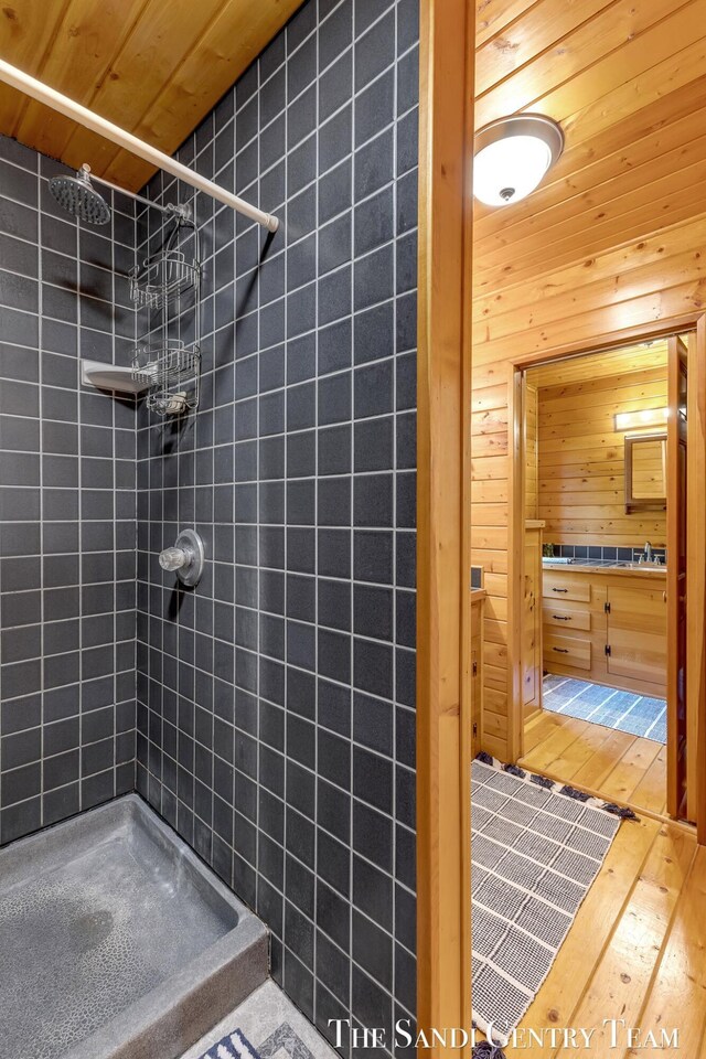 7120 Quarterline Rd, Spring Lake, MI 49456 - bathroom featuring a tile shower, wood ceiling, and wood-type flooring
