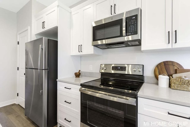 13654 Signature Dr, Holland, MI 49424 - kitchen featuring appliances with stainless steel finishes, light countertops, wood finished floors, and white cabinetry