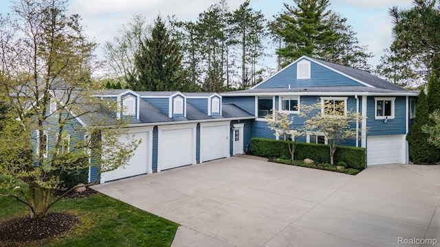 900 Indianwood Rd, Lake Orion, MI 48362 - view of front of house featuring a garage and concrete driveway