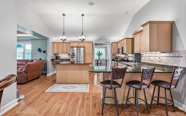 900 Indianwood Rd, Lake Orion, MI 48362 - kitchen featuring appliances with stainless steel finishes, a peninsula, decorative backsplash, a sink, and light wood finished floors