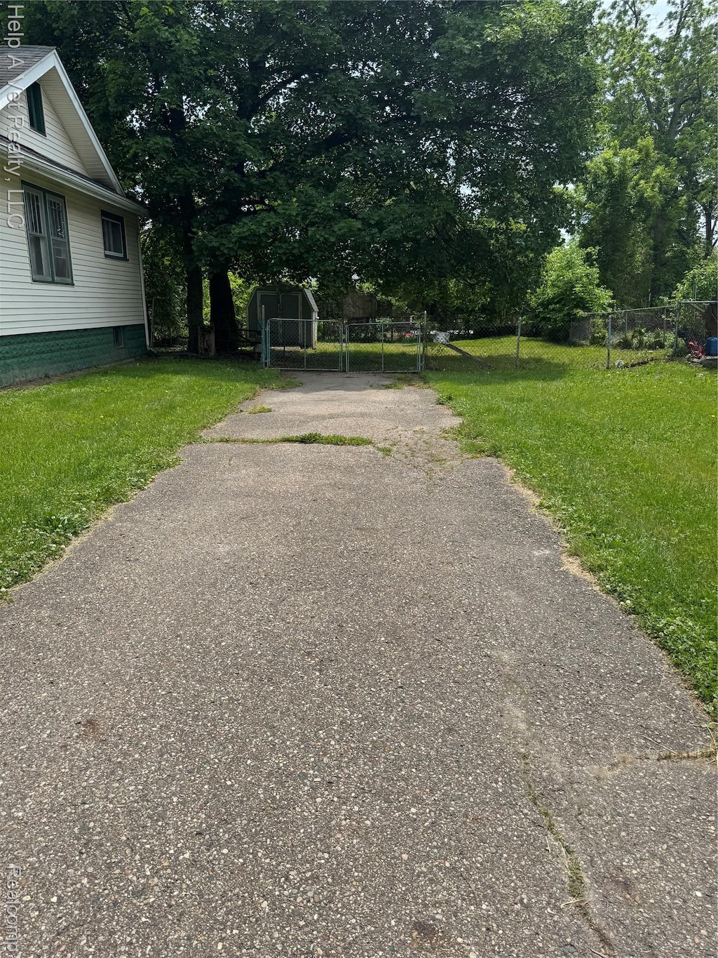 234 Mary St, Flint, MI 48503 - view of asphalt driveway with view of scattered trees