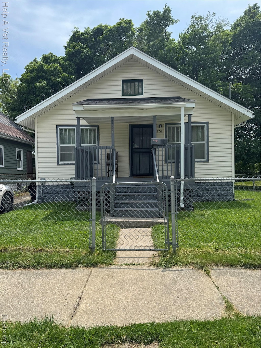 234 Mary St, Flint, MI 48503 - bungalow featuring a porch, a gate, and a fenced front yard