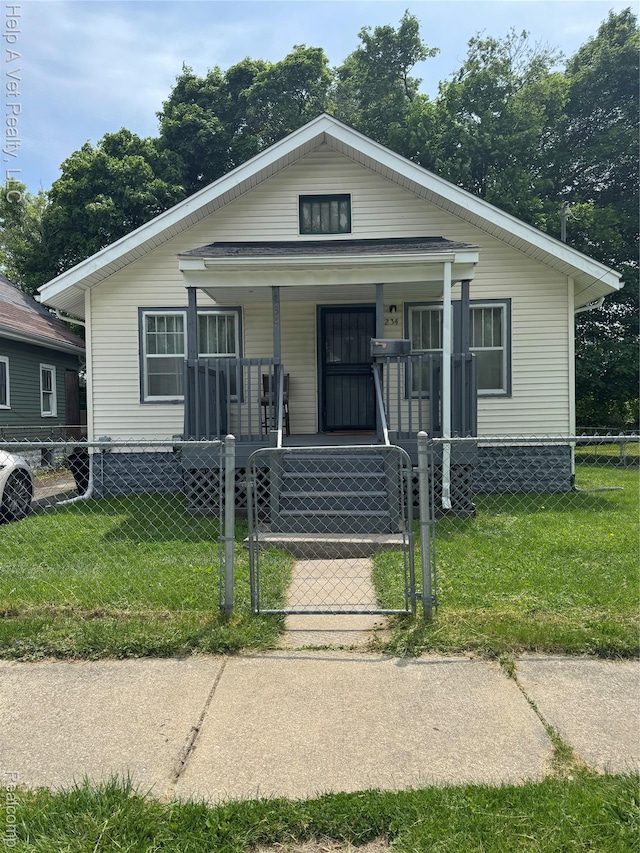 234 Mary St, Flint, MI 48503 - bungalow featuring a porch, a gate, and a fenced front yard