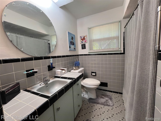 33200 Raphael Rd, Farmington, MI 48336 - full bath featuring vanity, toilet, tile walls, tile patterned floors, and a wainscoted wall
