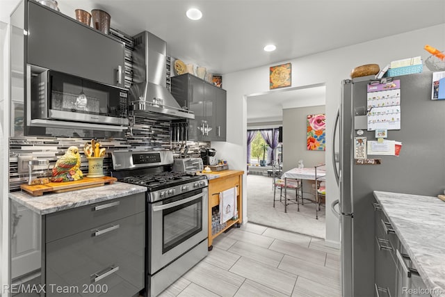 18155 Audette St, Dearborn, MI 48124 - kitchen featuring stainless steel appliances, wall chimney range hood, gray cabinetry, decorative backsplash, and recessed lighting