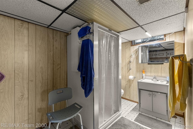 18155 Audette St, Dearborn, MI 48124 - full bathroom featuring wooden walls, a paneled ceiling, a stall shower, vanity, and toilet
