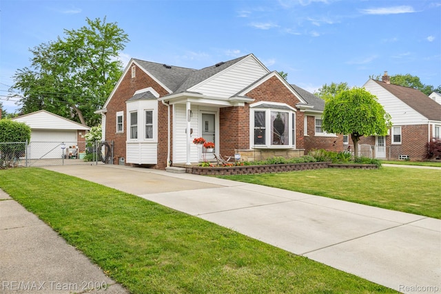 18155 Audette St, Dearborn, MI 48124 - bungalow-style home featuring brick siding, a shingled roof, a gate, a detached garage, and an outbuilding