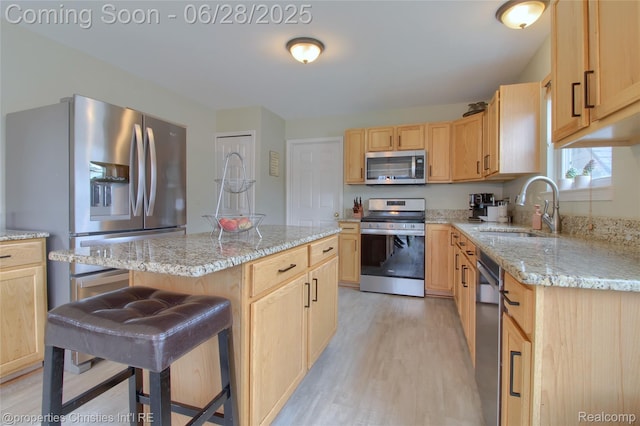 18594 Lawrence Ln, New Boston, MI 48164 - kitchen with stainless steel appliances, light wood-style floors, light brown cabinetry, light stone counters, and a kitchen island