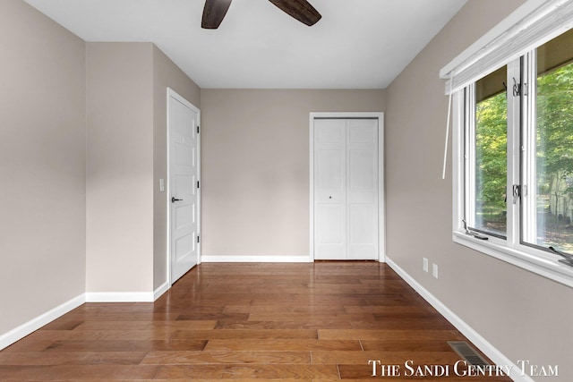 6372 Lake Harbor Rd, Norton Shores, MI 49441 - unfurnished bedroom with wood finished floors, baseboards, ceiling fan, and a closet