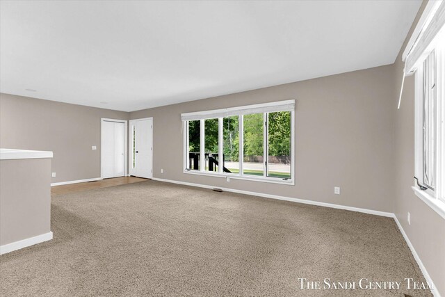 6372 Lake Harbor Rd, Norton Shores, MI 49441 - empty room featuring carpet flooring and baseboards