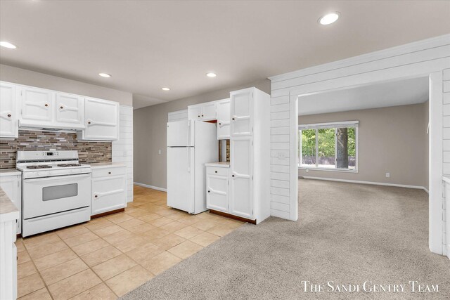 6372 Lake Harbor Rd, Norton Shores, MI 49441 - kitchen with white appliances, light countertops, white cabinets, recessed lighting, and backsplash