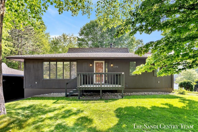 6372 Lake Harbor Rd, Norton Shores, MI 49441 - back of house featuring a yard, a wooden deck, and roof with shingles