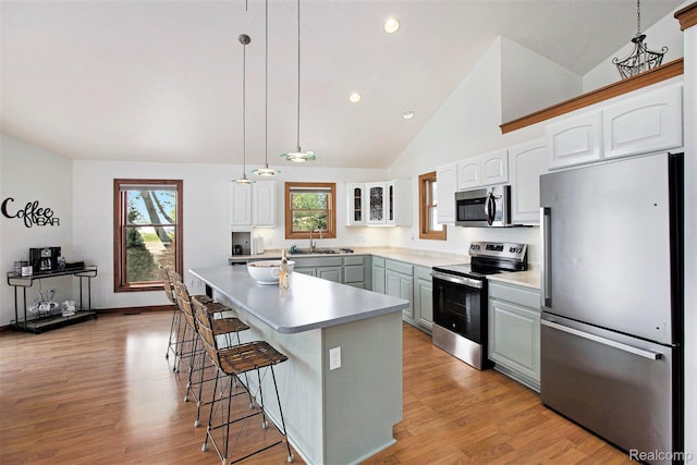 8721 Bayview Rd, Onekama, MI 49675 - kitchen with stainless steel appliances, a kitchen bar, light wood-style floors, plenty of natural light, and recessed lighting