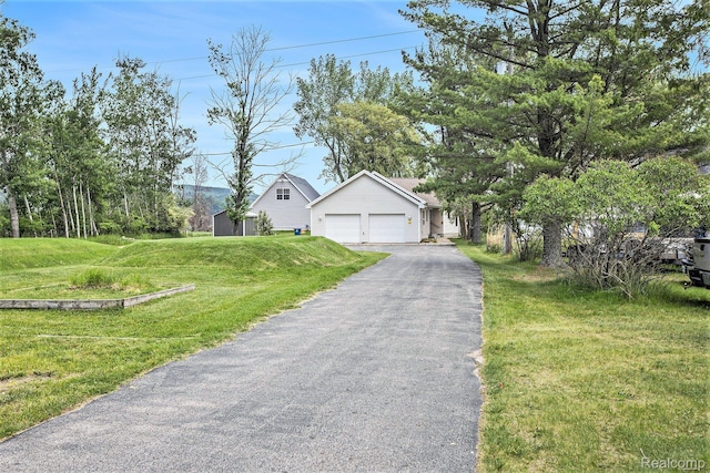 8721 Bayview Rd, Onekama, MI 49675 - view of front facade with driveway, a front lawn, and a garage