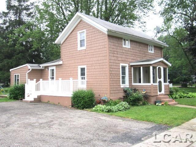311 Tiffin St, Hudson, MI 49247 - view of front facade with a sunroom and asphalt driveway