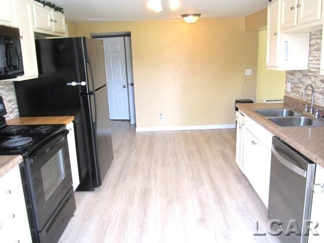 311 Tiffin St, Hudson, MI 49247 - kitchen featuring black appliances, a sink, light wood-style flooring, white cabinets, and baseboards