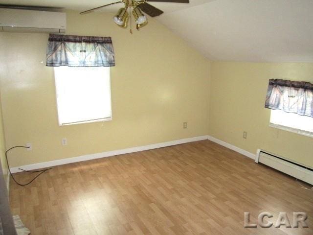 311 Tiffin St, Hudson, MI 49247 - bonus room with ceiling fan, wood finished floors, vaulted ceiling, baseboards, and a wall mounted air conditioner