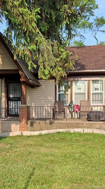 15859 Braile St, Detroit, MI 48223 - back of property with covered porch, a lawn, and roof with shingles