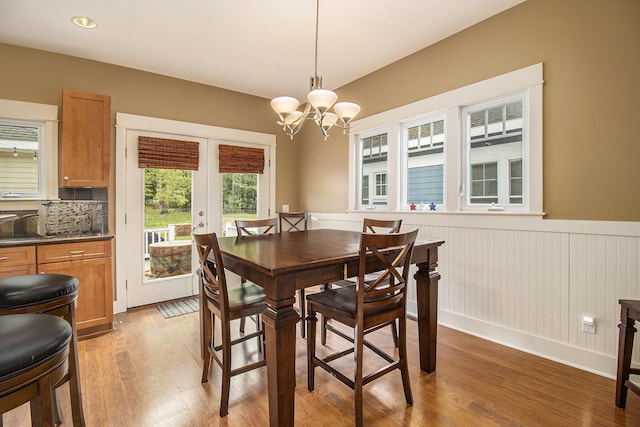 23 Kenneth St, Pentwater, MI 49449 - dining room with french doors, light wood finished floors, wainscoting, and a chandelier