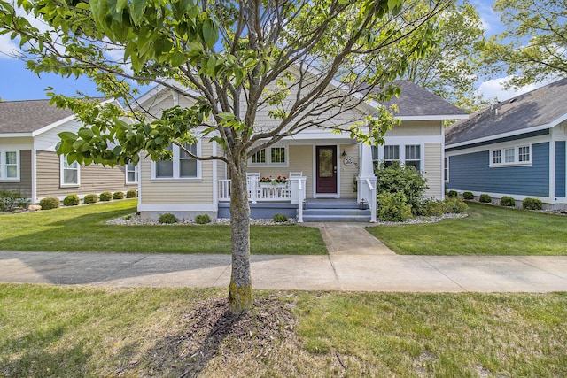 23 Kenneth St, Pentwater, MI 49449 - view of front facade featuring covered porch and a front lawn