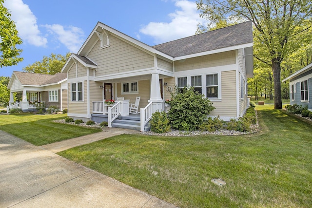 23 Kenneth St, Pentwater, MI 49449 - view of front of property featuring a porch, roof with shingles, and a front lawn