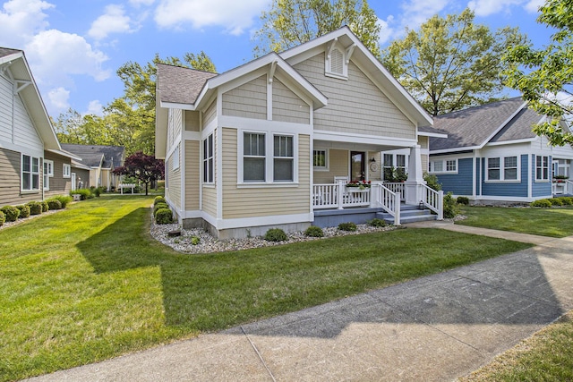 23 Kenneth St, Pentwater, MI 49449 - view of front of house with a porch, a front yard, and roof with shingles