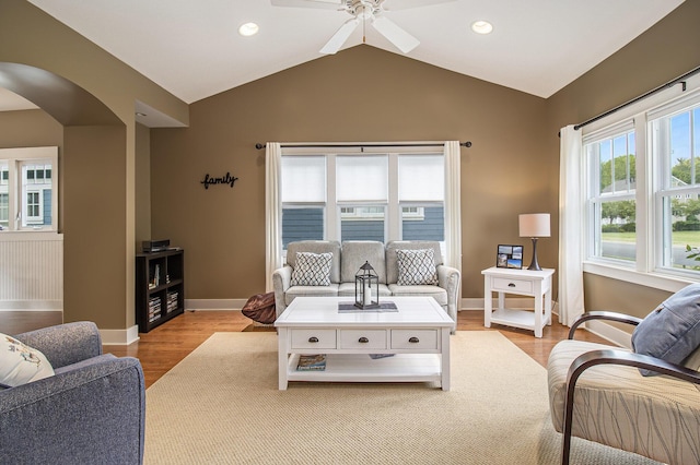23 Kenneth St, Pentwater, MI 49449 - living area featuring arched walkways, baseboards, a ceiling fan, light wood-style floors, and lofted ceiling