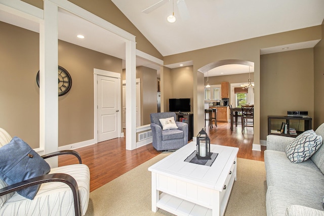 23 Kenneth St, Pentwater, MI 49449 - living room with arched walkways, ceiling fan, wood finished floors, vaulted ceiling, and baseboards