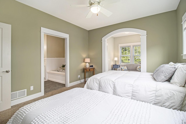 23 Kenneth St, Pentwater, MI 49449 - carpeted bedroom featuring arched walkways, baseboards, connected bathroom, and a ceiling fan