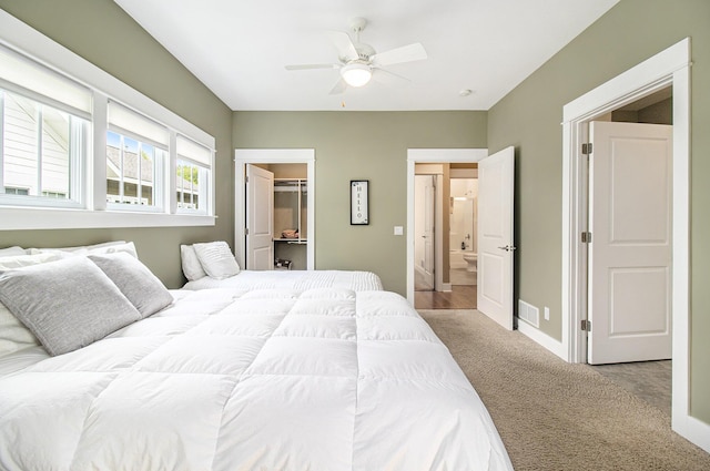 23 Kenneth St, Pentwater, MI 49449 - carpeted bedroom featuring a walk in closet, baseboards, and a ceiling fan