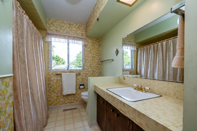 312 S Veronica Ct, Saint Joseph, MI 49085 - full bath featuring tile patterned floors, toilet, vanity, tasteful backsplash, and baseboards