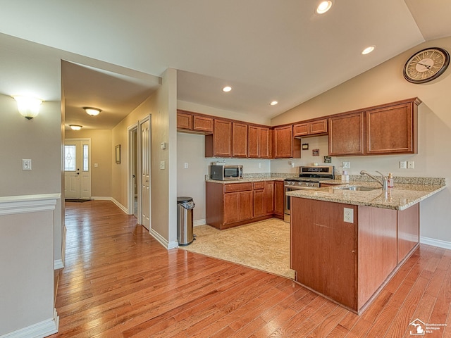 8721 E Park Ridge Cir, Newport, MI 48166 - kitchen featuring stainless steel appliances, a sink, a peninsula, brown cabinets, and light wood-style flooring
