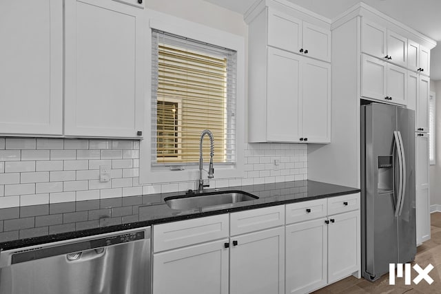 627 Fairview Ave NE Unit 2, Grand Rapids, MI 49503 - kitchen with stainless steel appliances, a sink, white cabinets, and dark stone countertops