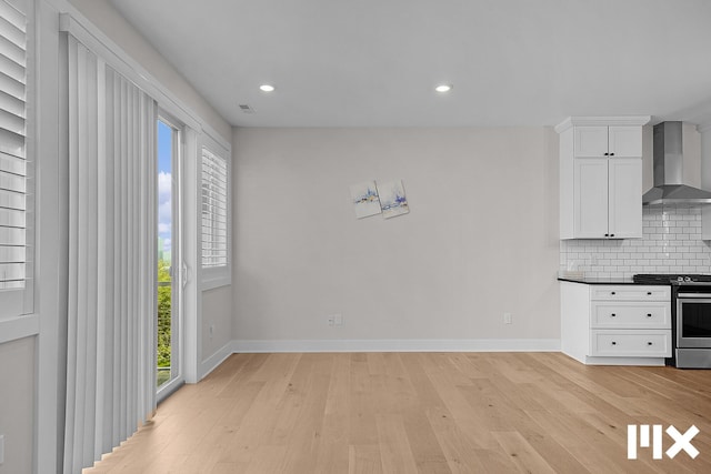 627 Fairview Ave NE Unit 2, Grand Rapids, MI 49503 - kitchen with stainless steel range with gas stovetop, wall chimney exhaust hood, decorative backsplash, baseboards, and recessed lighting