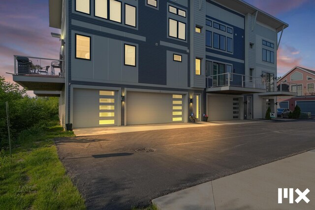 627 Fairview Ave NE Unit 2, Grand Rapids, MI 49503 - view of front facade with an attached garage, a balcony, board and batten siding, and driveway
