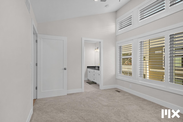 627 Fairview Ave NE Unit 2, Grand Rapids, MI 49503 - unfurnished bedroom with light colored carpet, baseboards, a high ceiling, and ensuite bath