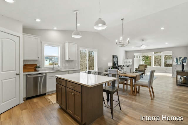 345 Hickory Valley Dr, Kalamazoo, MI 49009 - kitchen with stainless steel dishwasher, a breakfast bar area, light countertops, tasteful backsplash, and vaulted ceiling