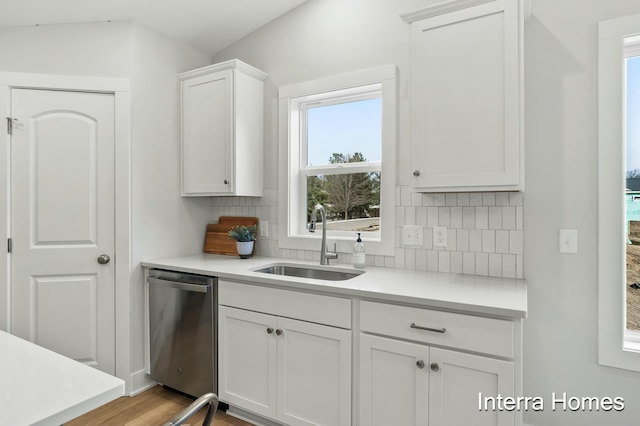 345 Hickory Valley Dr, Kalamazoo, MI 49009 - kitchen featuring stainless steel dishwasher, a sink, decorative backsplash, and light countertops