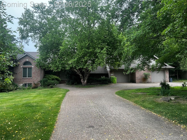 3680 Miller Rd, Ann Arbor, MI 48103 - view of property hidden behind natural elements featuring brick siding, driveway, a front yard, and an attached garage