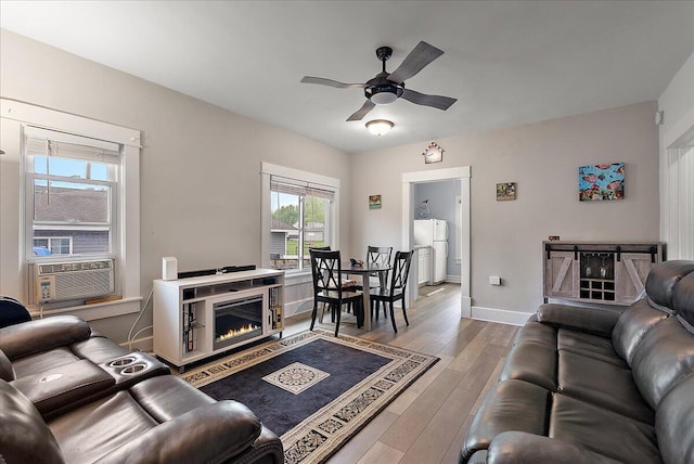 4940 Pottawatamie Path, Watervliet, MI 49098 - living room featuring a ceiling fan, light wood-style flooring, baseboards, and a glass covered fireplace