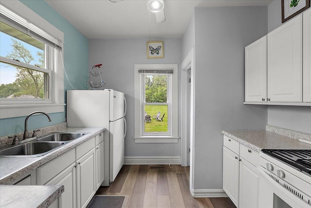 4940 Pottawatamie Path, Watervliet, MI 49098 - kitchen with a sink, white appliances, wood finished floors, white cabinets, and baseboards