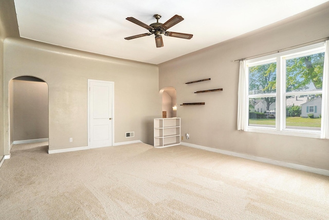 1386 W Broadway Ave, Muskegon, MI 49441 - unfurnished bedroom featuring arched walkways, carpet, baseboards, and ceiling fan